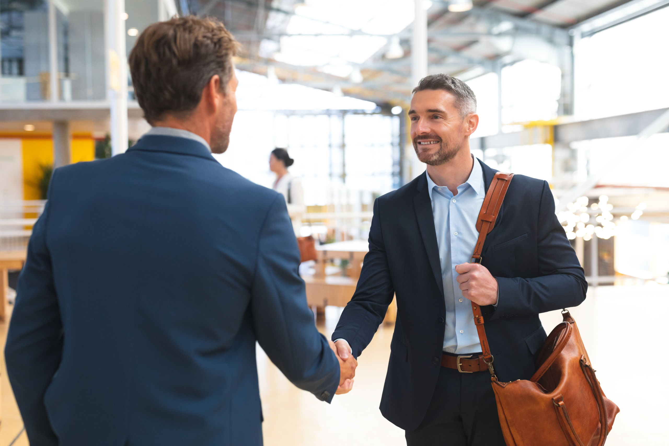businessmen shaking hands with each other in office